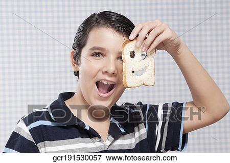 Boy holding a slice of bread View Large Photo Image Stock Photo - Boy holding a slice of bread. Fotosearch