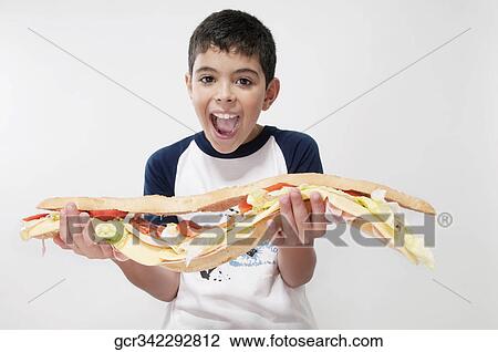 Boy holding a submarine sandwich View Large Photo Image Stock Image - Boy holding a submarine sandwich. Fotosearch