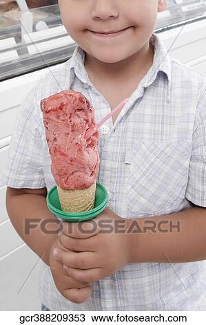 Boy holding an ice cream and smiling View Large Photo Image Stock Image - Boy holding an ice cream and smiling. Fotosearch