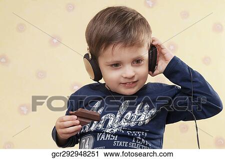 Boy listening to music and holding a chocolate View Large Photo Image Stock Image - Boy listening to music and holding a chocolate. Fotosearch