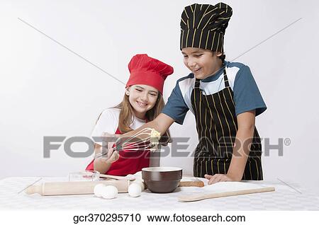 Boy looking at whipped batter with his sister View Large Photo Image Stock Image - Boy looking at whipped batter with his sister. Fotosearch