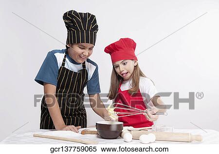 Boy looking at whipped batter with his sister View Large Photo Image Stock Photography - Boy looking at whipped batter with his sister. Fotosearch