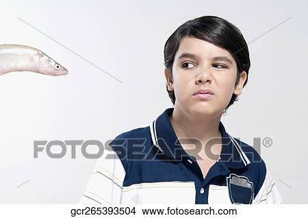 Boy making face after seeing a raw fish View Large Photo Image Picture - Boy making face after seeing a raw fish. Fotosearch