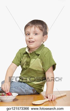 Boy picking strawberry from a bowl View Large Photo Image Stock Photograph - Boy picking strawberry from a bowl. Fotosearch