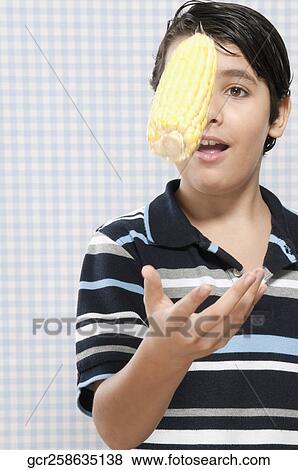 Boy playing with a corn cob View Large Photo Image Stock Photo - Boy playing with a corn cob. Fotosearch