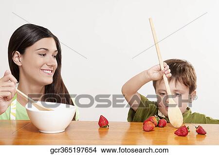 Boy playing with strawberries at a dining table View Large Photo Image Picture - Boy playing with strawberries at a dining table. Fotosearch