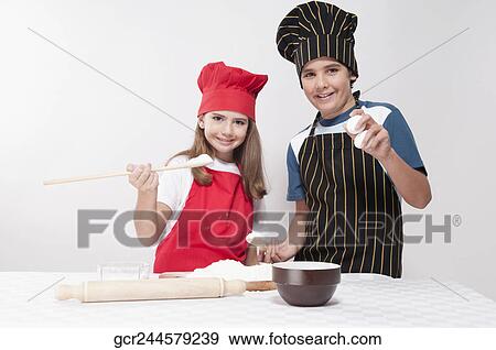 Boy preparing a cake with his sister View Large Photo Image Stock Photo - Boy preparing a cake with his sister. Fotosearch