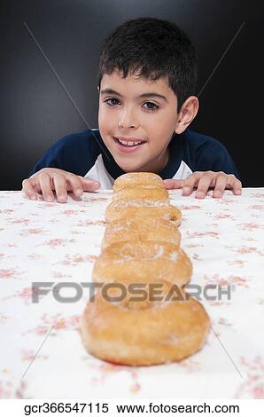 Boy with a row of donuts at a table View Large Photo Image Stock Photography - Boy with a row of donuts at a table. Fotosearch