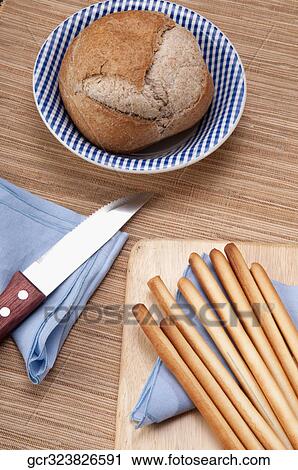 Bun with breadsticks and a knife View Large Photo Image Stock Image - Bun with breadsticks and a knife. Fotosearch