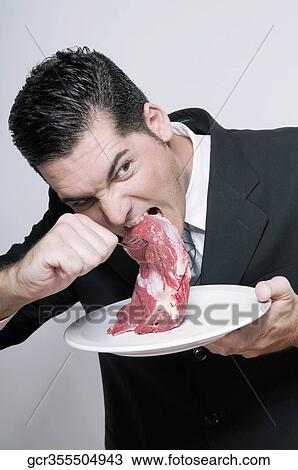 Businessman biting a shank of meat View Large Photo Image Stock Image - Businessman biting a shank of meat. Fotosearch