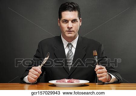 Businessman eating a raw steak View Large Photo Image Stock Image - Businessman eating a raw steak. Fotosearch
