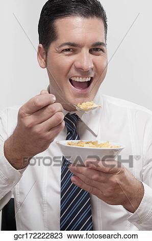 Businessman eating cereal View Large Photo Image Stock Image - Businessman eating cereal. Fotosearch