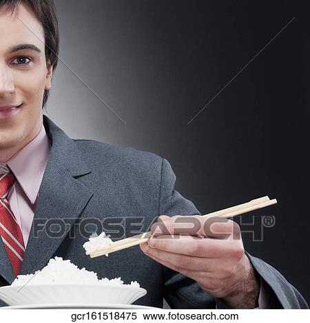 Businessman eating rice with chopsticks View Large Photo Image Stock Photography - Businessman eating rice with chopsticks. Fotosearch