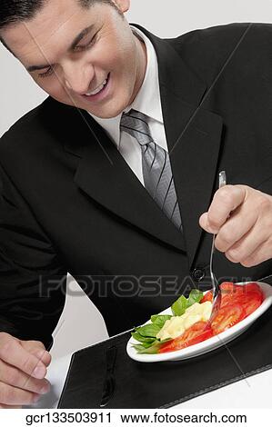 Businessman eating salad View Large Photo Image Stock Image - Businessman eating salad. Fotosearch