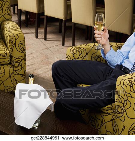 Businessman holding a glass of wine View Large Photo Image Stock Image - Businessman holding a glass of wine. Fotosearch