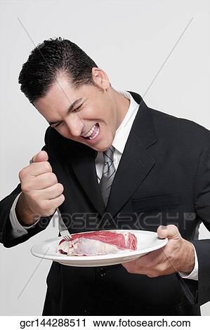 Businessman holding a plate of meat shank View Large Photo Image Stock Image - Businessman holding a plate of meat shank. Fotosearch
