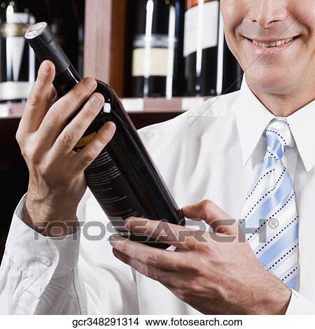 Businessman holding a wine bottle View Large Photo Image Picture - Businessman holding a wine bottle. Fotosearch