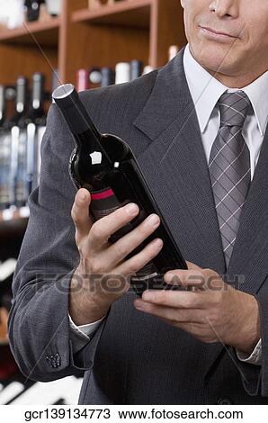 Businessman holding a wine bottle View Large Photo Image Stock Image - Businessman holding a wine bottle. Fotosearch