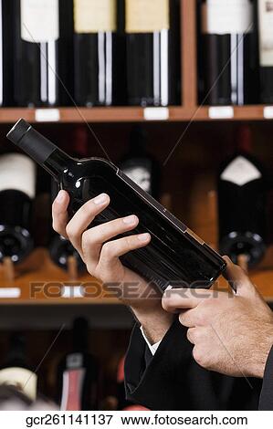 Businessman holding a wine bottle View Large Photo Image Stock Photo - Businessman holding a wine bottle. Fotosearch