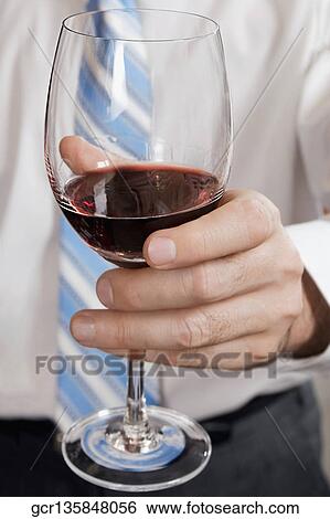 Businessman holding a wine glass View Large Photo Image Stock Photograph - Businessman holding a wine glass. Fotosearch