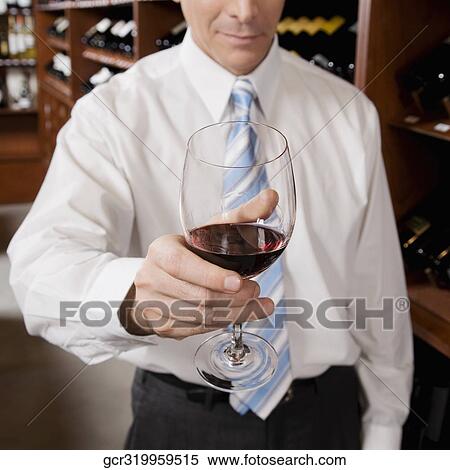 Businessman holding a wine glass View Large Photo Image Stock Photography - Businessman holding a wine glass. Fotosearch