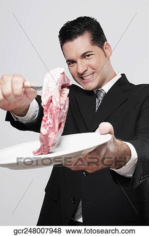 Businessman holding up a shank of meat View Large Photo Image Stock Photo - Businessman holding up a shank of meat. Fotosearch