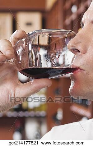 Stock Image - Businessman tasting wine in a cellar. Fotosearch