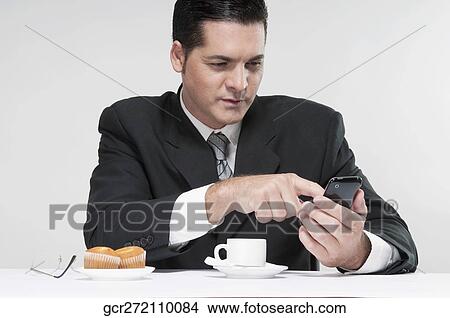 Businessman text messaging on a mobile phone View Large Photo Image Picture - Businessman text messaging on a mobile phone. Fotosearch