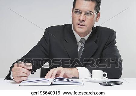 Businessman writing in a diary View Large Photo Image Stock Photograph - Businessman writing in a diary. Fotosearch