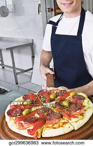 Chef preparing pizza in the kitchen View Large Photo Image Stock Image - Chef preparing pizza in the kitchen. Fotosearch