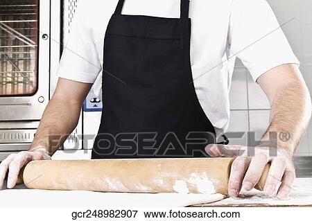Chef rolling dough with a rolling pin View Large Photo Image Stock Photo - Chef rolling dough with a rolling pin. Fotosearch