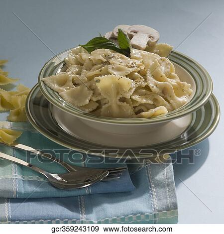 Stock Photo - Close-up of a bowl of bow tie pasta with a fork and a spoon. Fotosearch