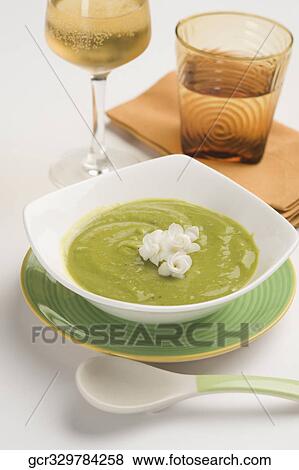 Close-up of a bowl of pea soup served with white wine View Large Photo Image Stock Photo - Close-up of a bowl of pea soup served with white wine. Fotosearch