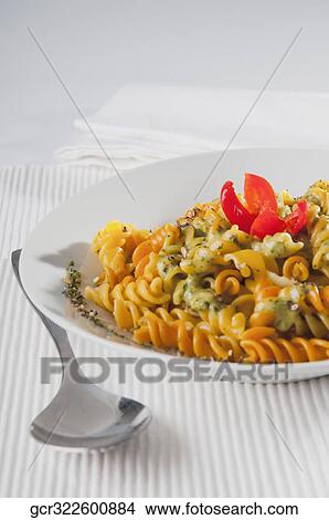 Close-up of a bowl of rotini topped with pesto sauce View Large Photo Image Picture - Close-up of a bowl of rotini topped with pesto sauce. Fotosearch