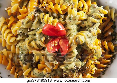 Close-up of a bowl of rotini topped with pesto sauce View Large Photo Image Stock Image - Close-up of a bowl of rotini topped with pesto sauce. Fotosearch