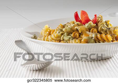 Close-up of a bowl of rotini topped with pesto sauce View Large Photo Image Stock Photography - Close-up of a bowl of rotini topped with pesto sauce. Fotosearch