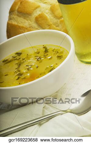 Stock Photo - Close-up of a bowl of soup with a loaf of bread. Fotosearch