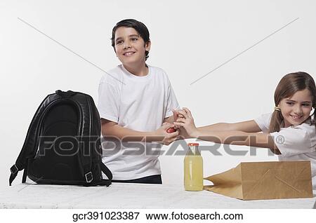Close-up of a boy and a girl fighting over an apple for lunch View Large Photo Image Stock Photo - Close-up of a boy and a girl fighting over an apple for lunch. Fotosearch