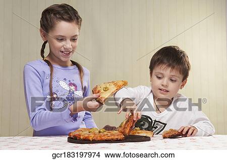 Close-up of a boy and a girl sharing pizza View Large Photo Image Picture - Close-up of a boy and a girl sharing pizza. Fotosearch