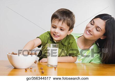 Close-up of a boy and his mother eating cereal View Large Photo Image Stock Photo - Close-up of a boy and his mother eating cereal. Fotosearch