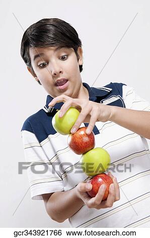 Stock Photograph - Close-up of a boy balancing apples. Fotosearch