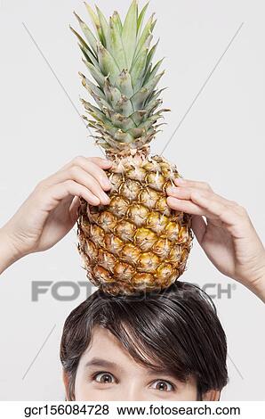 Close-up of a boy carrying a pineapple on his head View Large Photo Image Stock Photo - Close-up of a boy carrying a pineapple on his head. Fotosearch