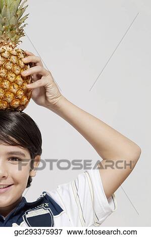 Close-up of a boy carrying a pineapple on his head View Large Photo Image Stock Photo - Close-up of a boy carrying a pineapple on his head. Fotosearch