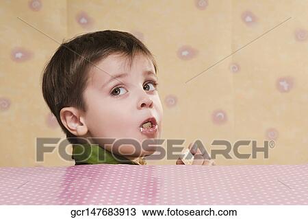Close-up of a boy eating a bar of white chocolate View Large Photo Image Stock Image - Close-up of a boy eating a bar of white chocolate. Fotosearch