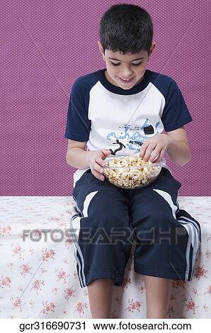 Close-up of a boy eating a bowl of popcorn View Large Photo Image Stock Image - Close-up of a boy eating a bowl of popcorn. Fotosearch