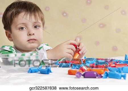 Stock Photo - Close-up of a boy eating a candy. Fotosearch