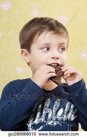 Close-up of a boy eating a chocolate bar View Large Photo Image Stock Photo - Close-up of a boy eating a chocolate bar. Fotosearch