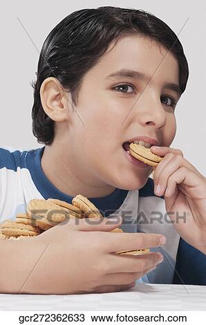 Close-up of a boy eating a cookie View Large Photo Image Stock Image - Close-up of a boy eating a cookie. Fotosearch