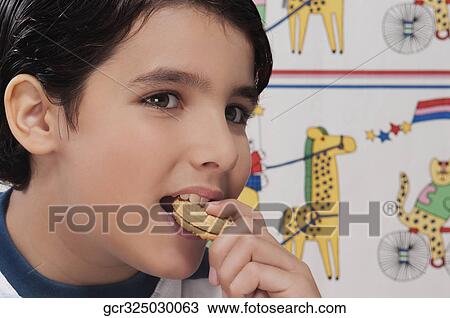 Close-up of a boy eating a cookie View Large Photo Image Stock Image - Close-up of a boy eating a cookie. Fotosearch