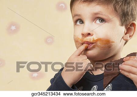 Close-up of a boy eating chocolate View Large Photo Image Picture - Close-up of a boy eating chocolate. Fotosearch